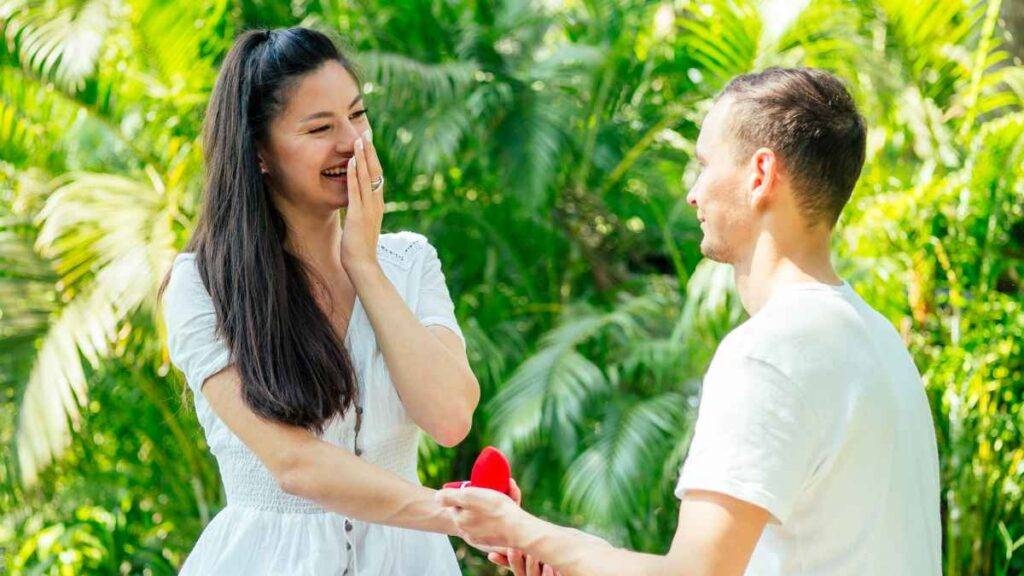 Couple holding hands with a ring box with cute proposal line for him